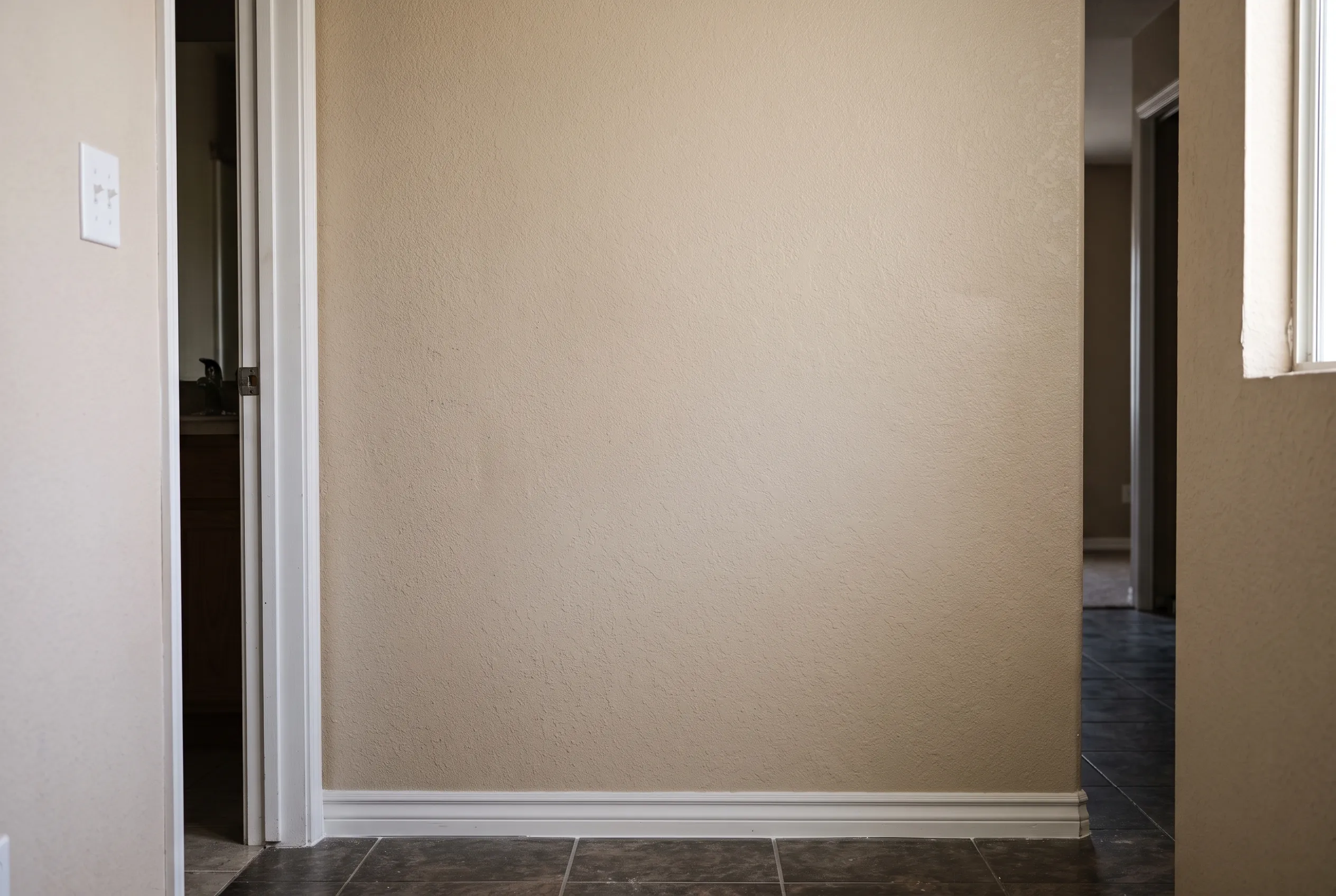 The same wall rebuilt, textured, painted, and finished with new baseboard