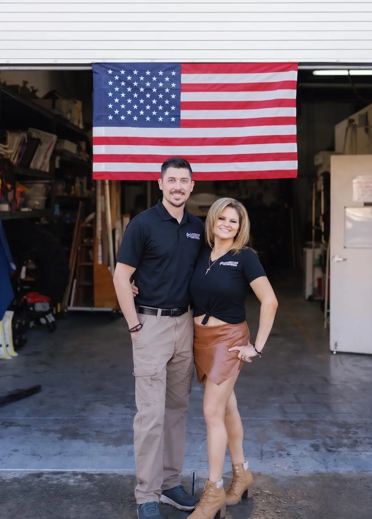 Tony Cuomo and his wife, owners of Maintenance America, in front of an American flag